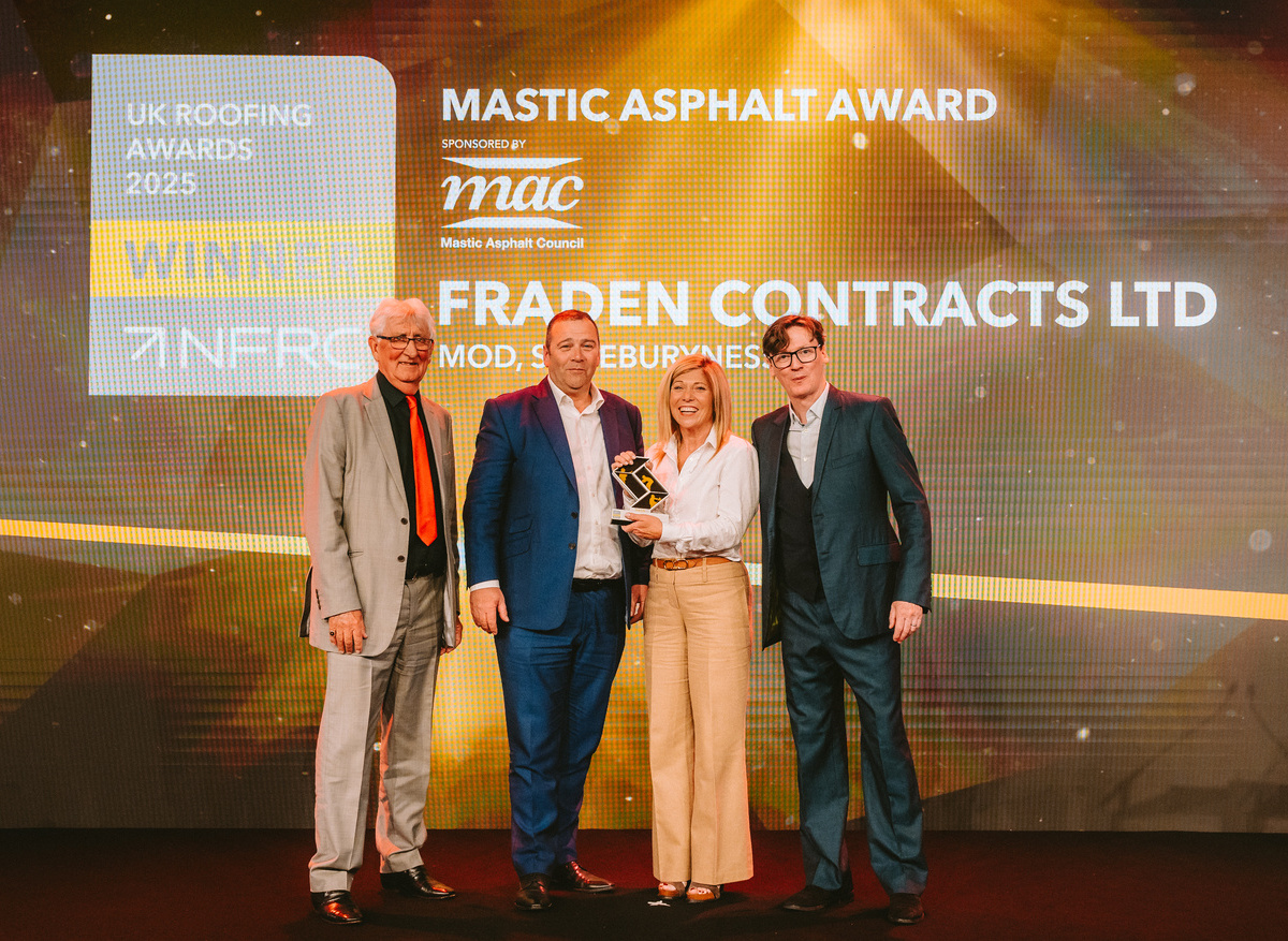Fraden Contracts Team Members posing with Ed Byrne on stage with NFRC UK Roofing Award Win