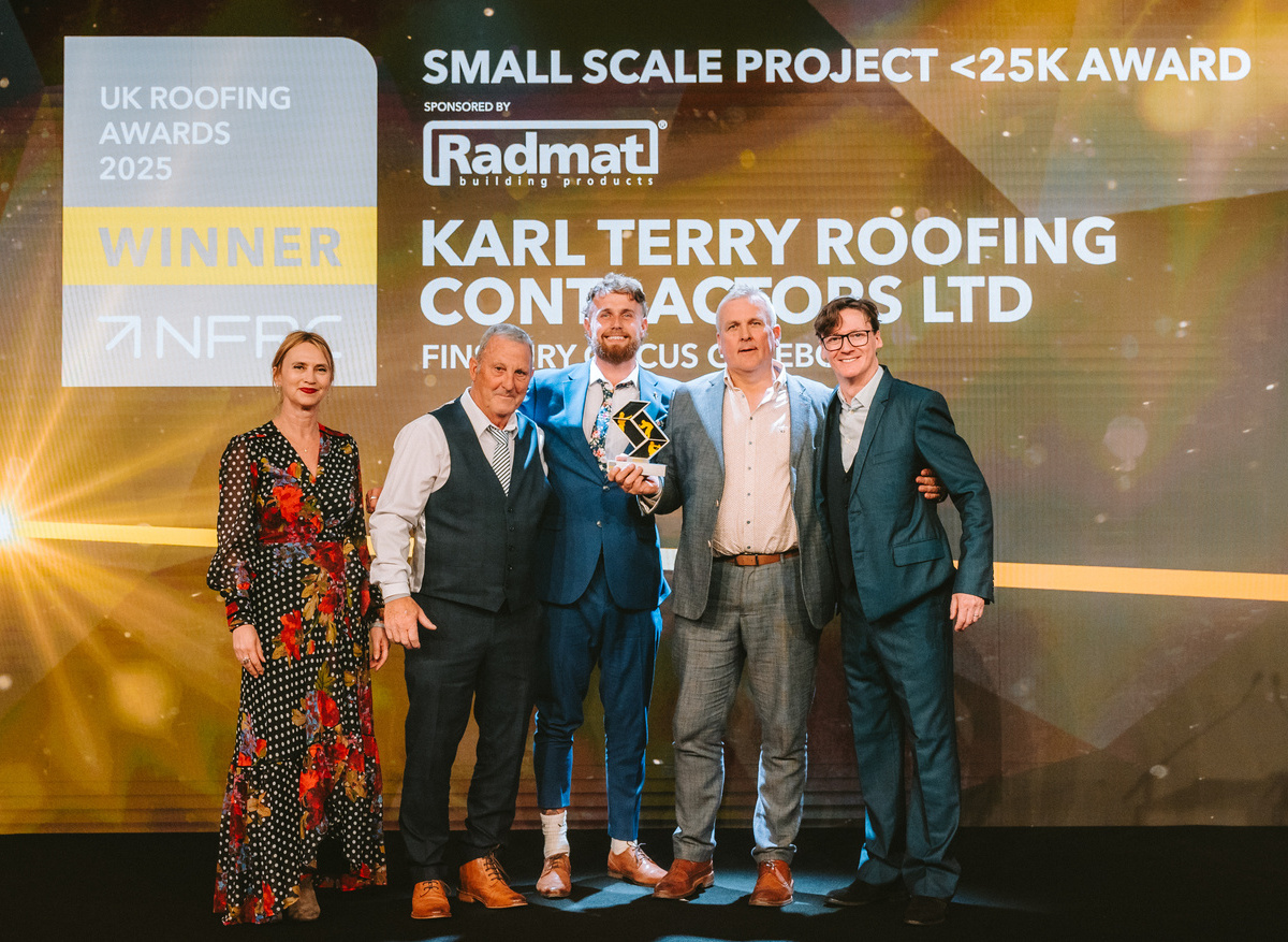 Karl Terry Roofing Contractors Ltd  team members with Ed Byrne on stage celebrating award win
